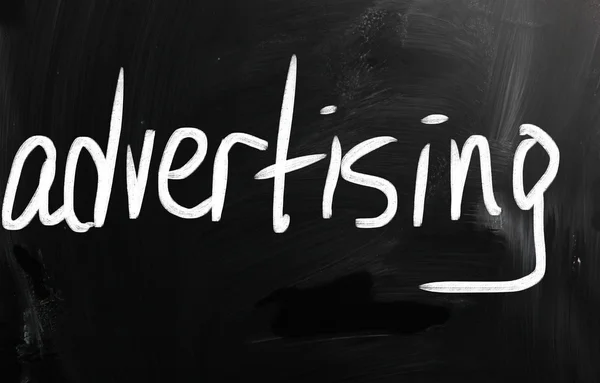 The word "advertising" handwritten with white chalk on a blackbo — Stock Photo, Image