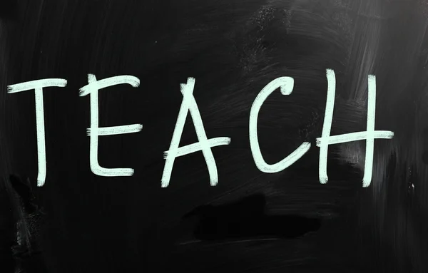 "Enseigner "écrit à la main avec de la craie blanche sur un tableau noir — Photo