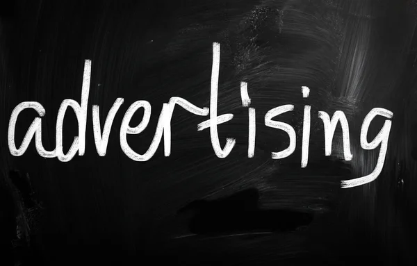 The word "advertising" handwritten with white chalk on a blackbo — Stock Photo, Image