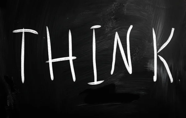 Het woord "think" handgeschreven met wit krijt op een schoolbord — Stockfoto