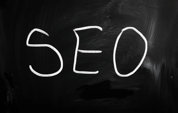 The word "SEO" handwritten with white chalk on a blackboard — Stock Photo, Image