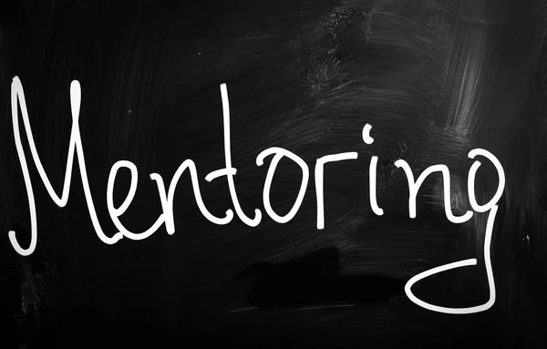 The word "Mentoring" handwritten with white chalk on a blackboar — Stock Photo, Image