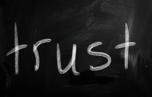 Ordet "förtroende" handskrivna med vit krita på en svart tavla — Stockfoto