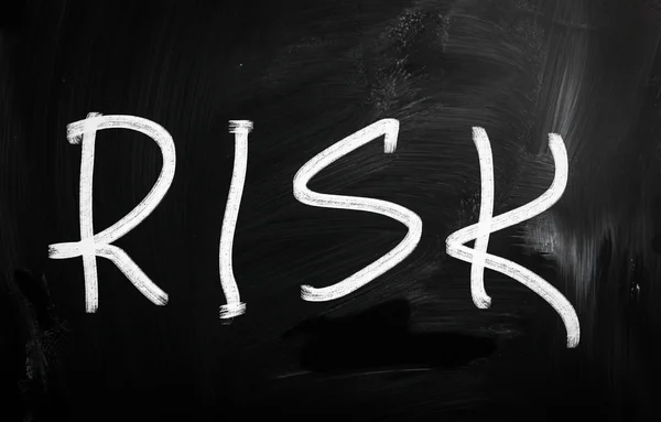 Het woord "risico" handgeschreven met wit krijt op een schoolbord — Stockfoto
