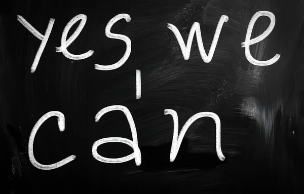 "Yes, we can!" handwritten with white chalk on a blackboard — Stock Photo, Image