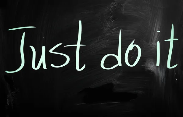 "Just Do It "handwritten with white chalk on a blackboard — стоковое фото