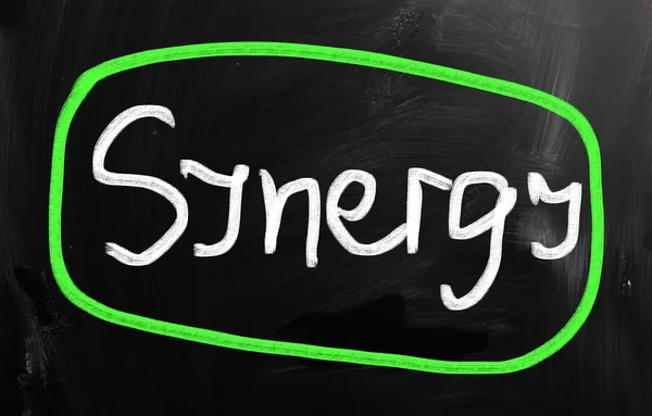 The word "Synergy" handwritten with white chalk on a blackboard — Stock Photo, Image