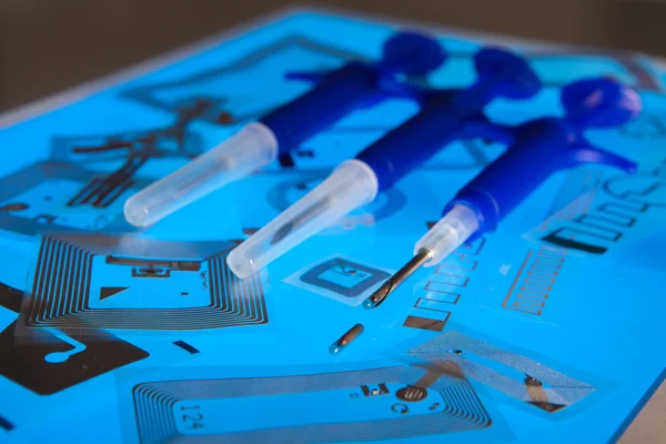 RFID implantation syringes and chips on RFID tags — Stock Photo, Image
