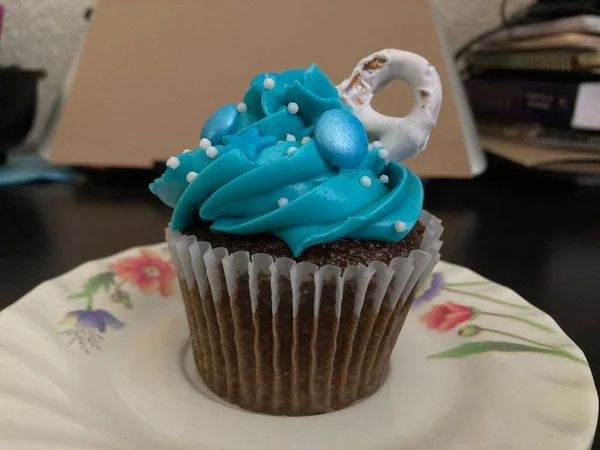 Chocolate cupcakes with blue frosting and sprinkles