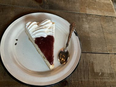 Çilekli ve beyaz kremalı bir dilim cheesecake.