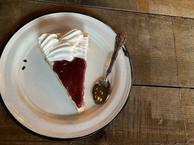 Çilekli ve beyaz kremalı bir dilim cheesecake.