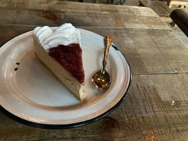 Çilekli ve beyaz kremalı bir dilim cheesecake.