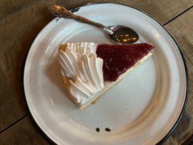 Çilekli ve beyaz kremalı bir dilim cheesecake.