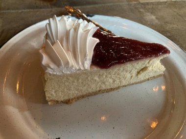 Çilekli ve beyaz kremalı bir dilim cheesecake.