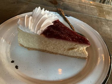 Çilekli ve beyaz kremalı bir dilim cheesecake.