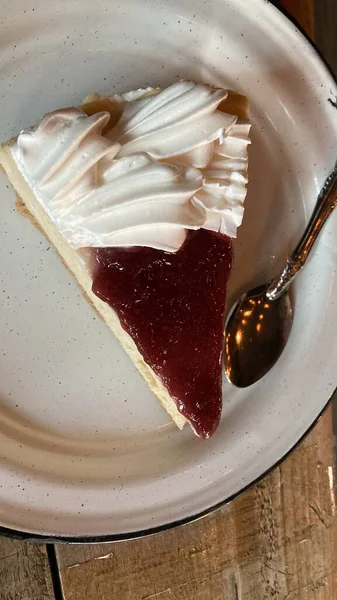 Çilekli ve beyaz kremalı bir dilim cheesecake.