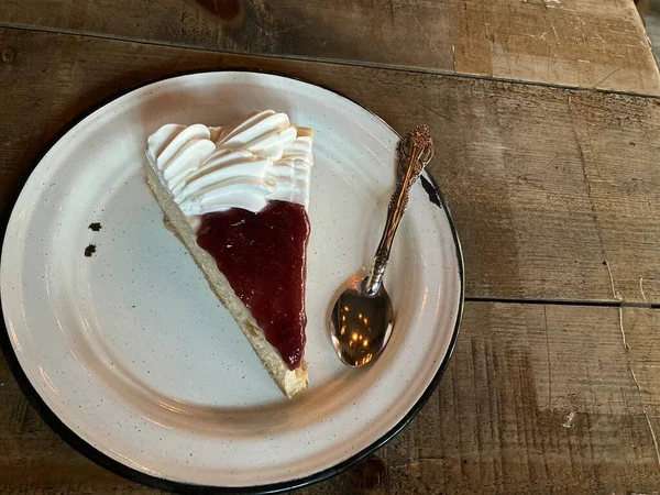 Çilekli ve beyaz kremalı bir dilim cheesecake.
