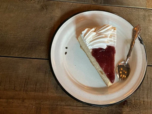 Çilekli ve beyaz kremalı bir dilim cheesecake.