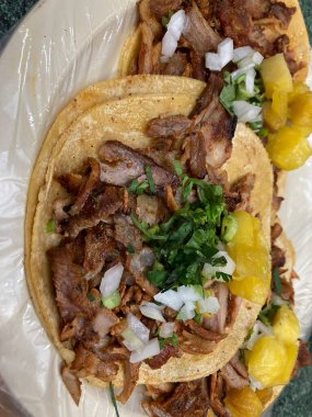 mexican tacos al pastor with pineapple, onion, and cilatro