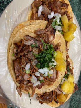 mexican tacos al pastor with pineapple, onion, and cilatro