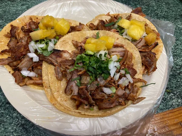 mexican tacos al pastor with pineapple, onion, and cilatro