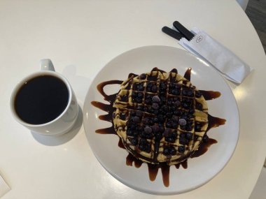 Kahvaltı için beyaz tabakta çikolatalı waffle 'lar hazır.