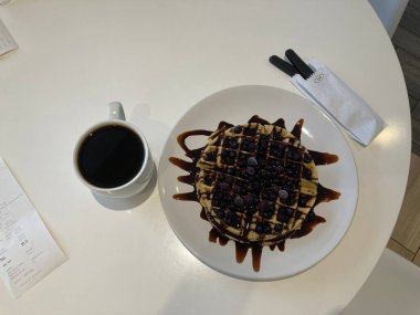 Kahvaltı için beyaz tabakta çikolatalı waffle 'lar hazır.