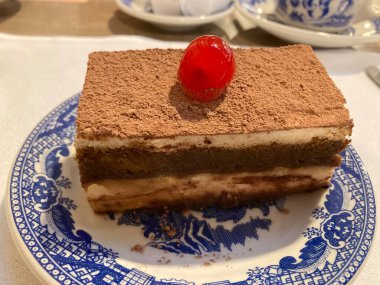 slice of tiramisu coffee cake with a cherry on top