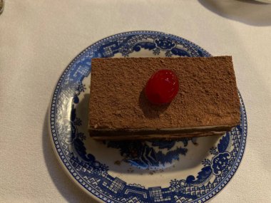 slice of tiramisu coffee cake with a cherry on top