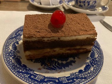 slice of tiramisu coffee cake with a cherry on top
