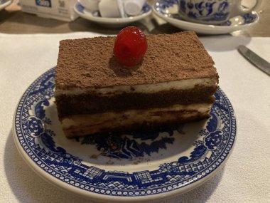 slice of tiramisu coffee cake with a cherry on top