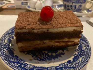 slice of tiramisu coffee cake with a cherry on top