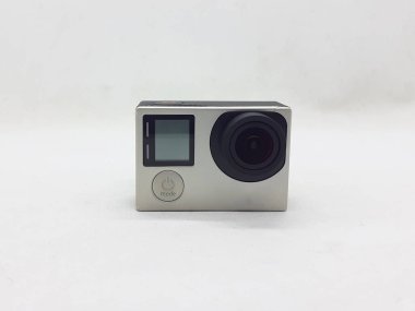 Beyaz izolasyon arka planında aksesuarları olan küçük siyah ve gri bir kamera.