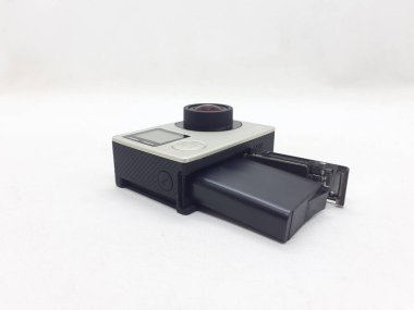 Beyaz izolasyon arka planında aksesuarları olan küçük siyah ve gri bir kamera.