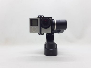 Beyaz izolasyon arka planında aksesuarları olan küçük siyah ve gri bir kamera.