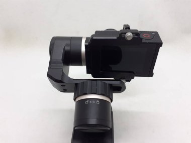 Beyaz izolasyon arka planında aksesuarları olan küçük siyah ve gri bir kamera.