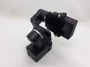 Beyaz izolasyon arka planında aksesuarları olan küçük siyah ve gri bir kamera.