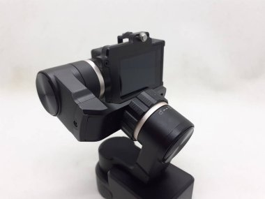 Beyaz izolasyon arka planında aksesuarları olan küçük siyah ve gri bir kamera.