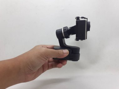 Beyaz izolasyon arka planında aksesuarları olan küçük siyah ve gri bir kamera.