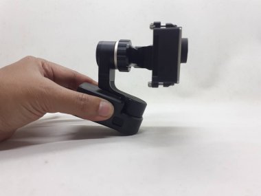 Beyaz izolasyon arka planında aksesuarları olan küçük siyah ve gri bir kamera.