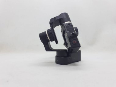 Beyaz izolasyon arka planında aksesuarları olan küçük siyah ve gri bir kamera.