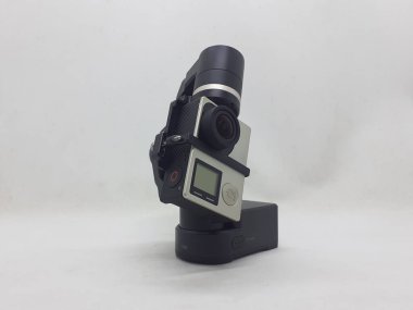 Beyaz izolasyon arka planında aksesuarları olan küçük siyah ve gri bir kamera.