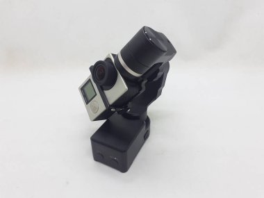 Beyaz izolasyon arka planında aksesuarları olan küçük siyah ve gri bir kamera.