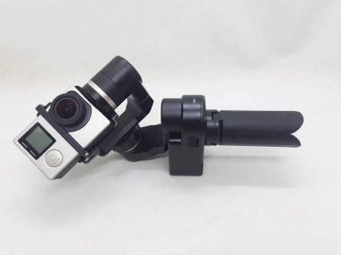 Beyaz izolasyon arka planında aksesuarları olan küçük siyah ve gri bir kamera.