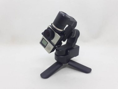 Beyaz izolasyon arka planında aksesuarları olan küçük siyah ve gri bir kamera.