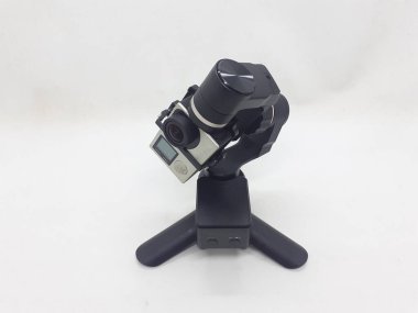 Beyaz izolasyon arka planında aksesuarları olan küçük siyah ve gri bir kamera.