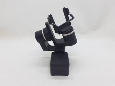 Beyaz izolasyon arka planında aksesuarları olan küçük siyah ve gri bir kamera.