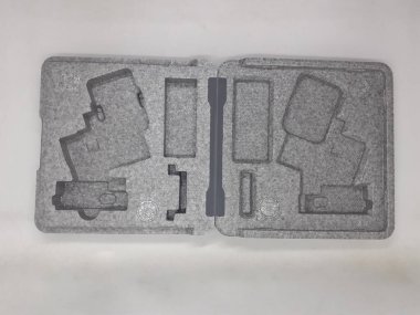 Beyaz izolasyon arka planında aksesuarları olan küçük siyah ve gri bir kamera.