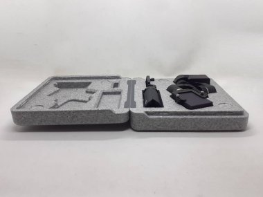 Beyaz izolasyon arka planında aksesuarları olan küçük siyah ve gri bir kamera.