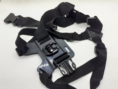 Beyaz izolasyon arka planında aksesuarları olan küçük siyah ve gri bir kamera.